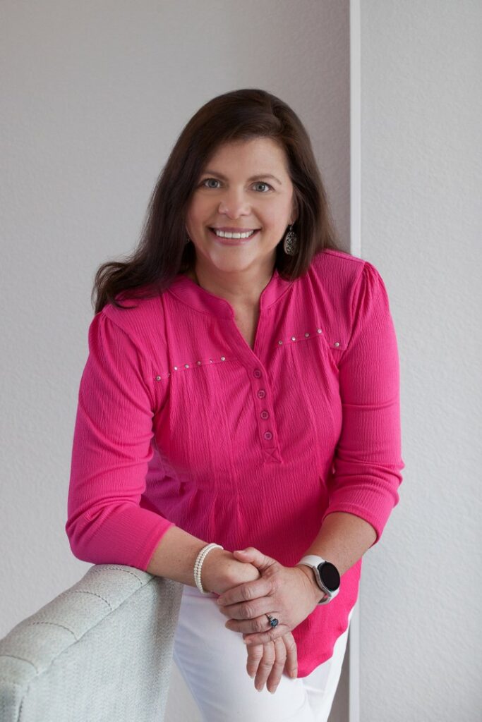 business portrait of a female real estate agent wearing a pink blouse in the studio