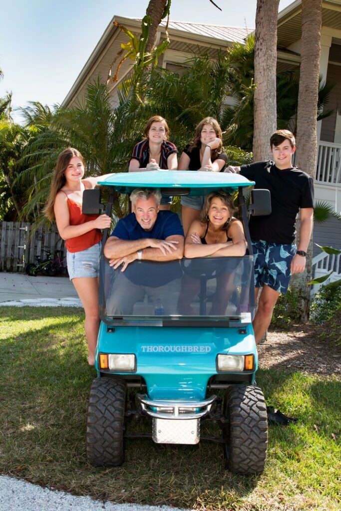 family portrait of six people in a golf cart