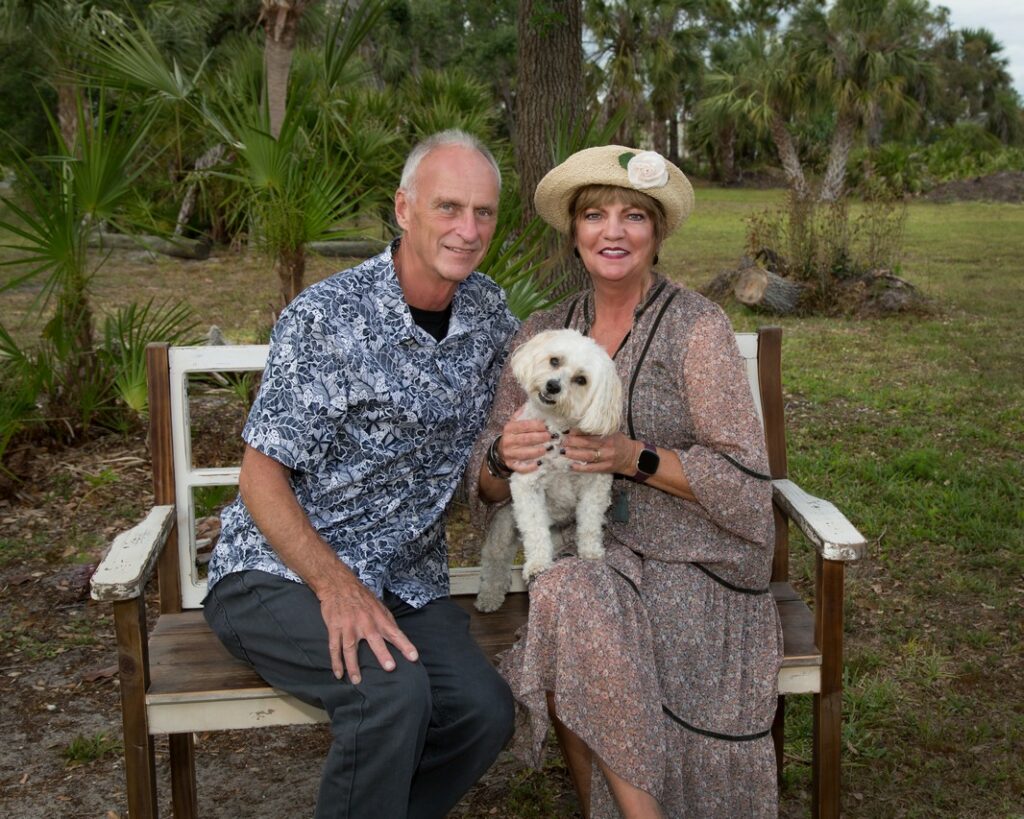 outdoor portrait of a mature couple and their small white dog