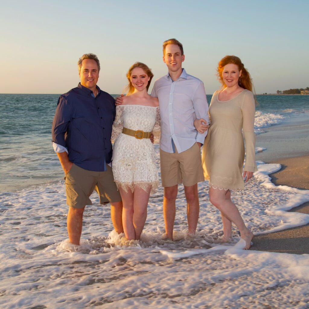parents with two young adult children on the beach